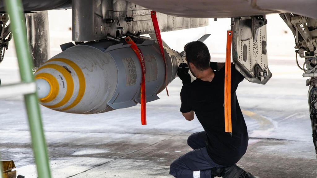 Israeli Air Force personnel prepare munitions on a fighter jet during the 12-day war against Iran 