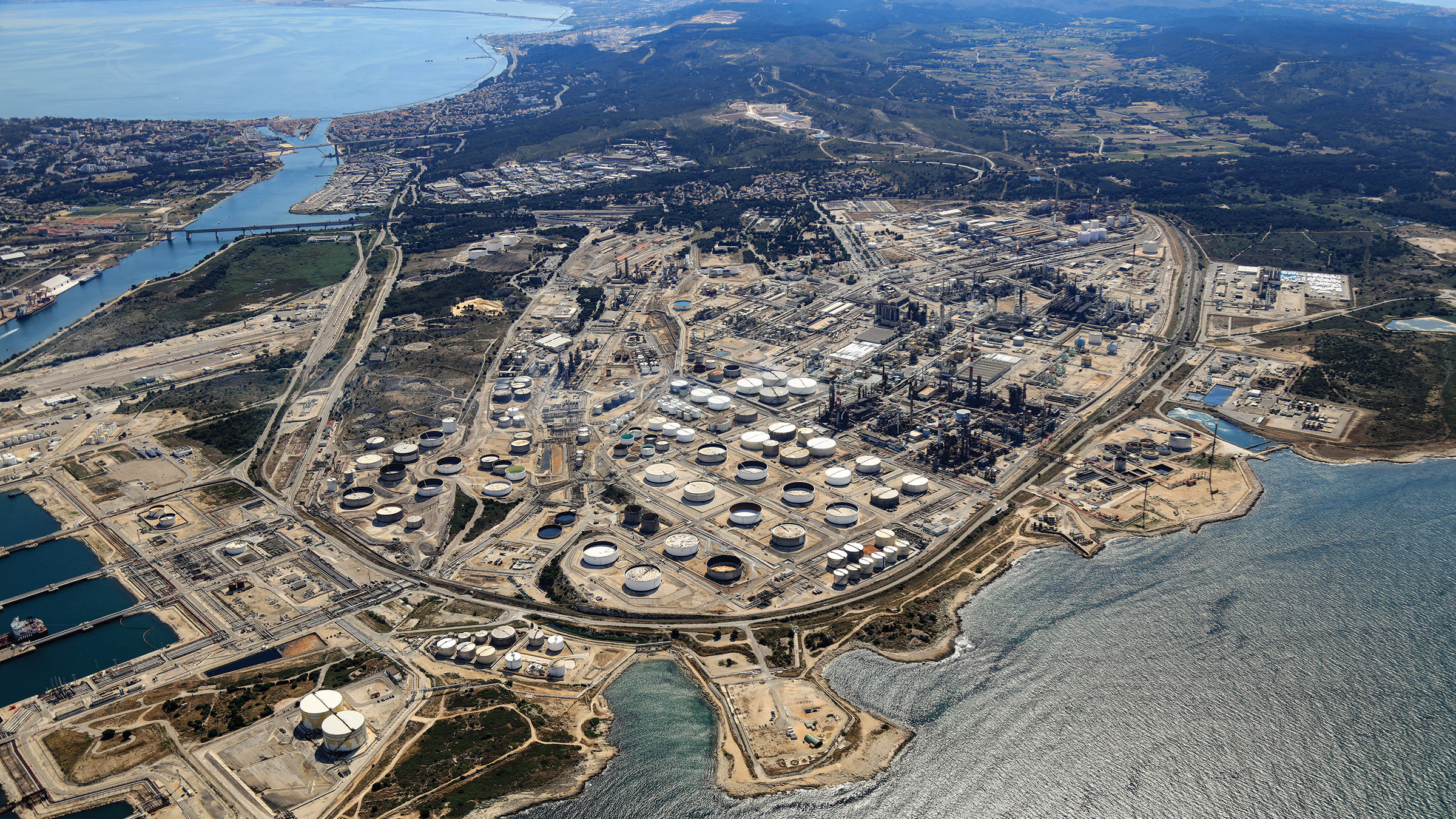 An aerial view of a petrochemical plant on a body of water.