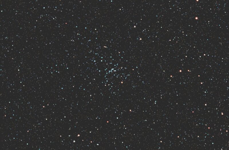 A rich grouping of blue stars (and sparse orange stars) with numerous fainter stars in the background.