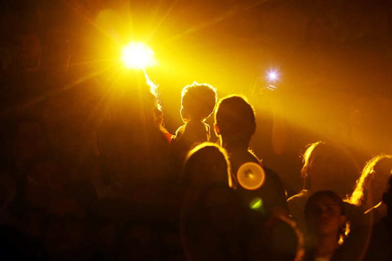 Audience members stand and are illuminated by yellow spot lights during the “Hallelujah” from Handel’s "Messiah"  during the "Songs of Hope" tour concert by The Tabernacle Choir and Orchestra at Temple Square at Ginasio do Ibirapuera in São Paulo, Brazil, Friday, Feb. 27, 2026.