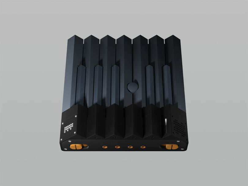 Black, rectangular electronic device with a ridged top surface and four gold-colored circular ports on the front panel.