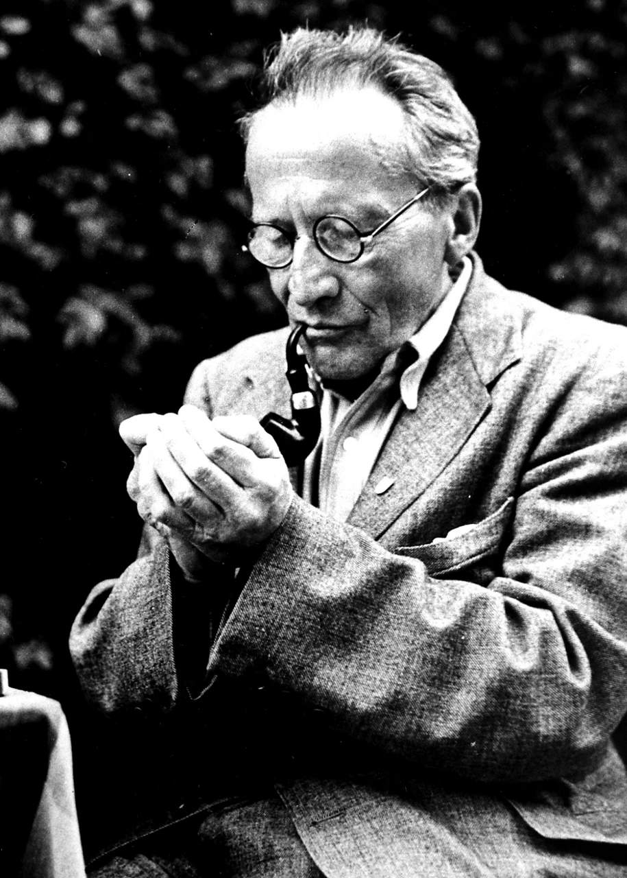 A photograph of a man smoking a pipe