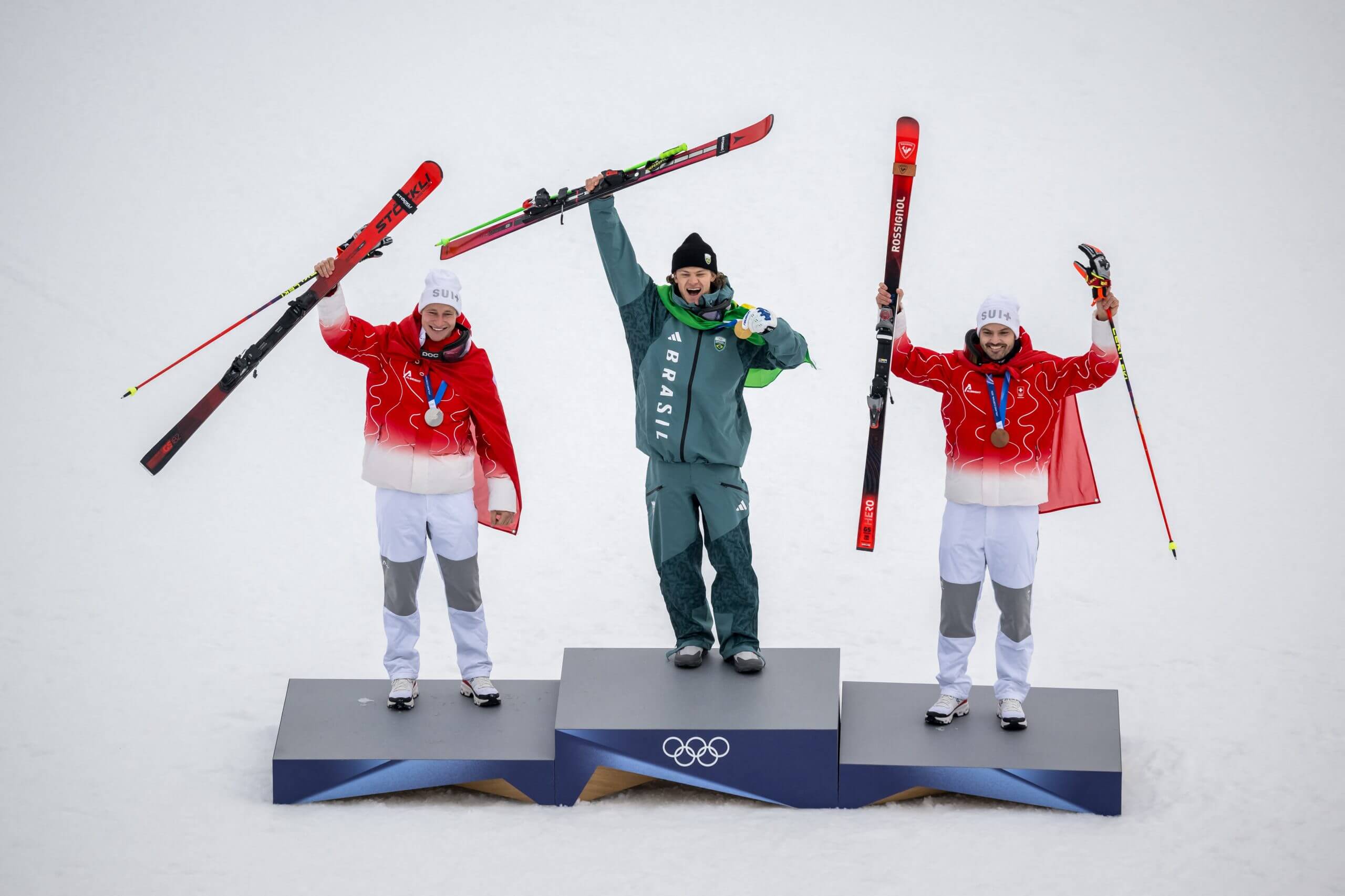 The three Olympic medalists in the men's giant slalom pose on the podium.