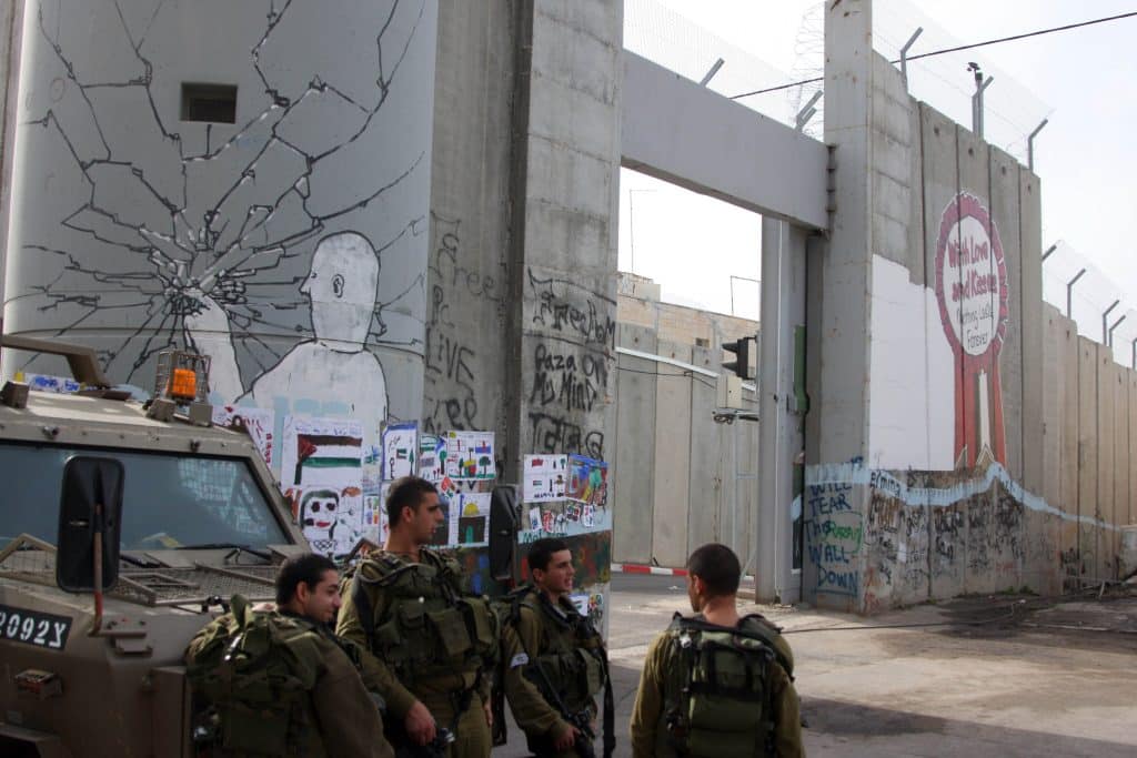 Israeli soldiers stand guard near the separation wall near Rachel's Tomb in Bethlehem, December 24, 2009. (Photo: Issam Rimawi/APA Images)