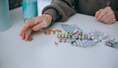 older adult hands next to lots of packets of tablet medication