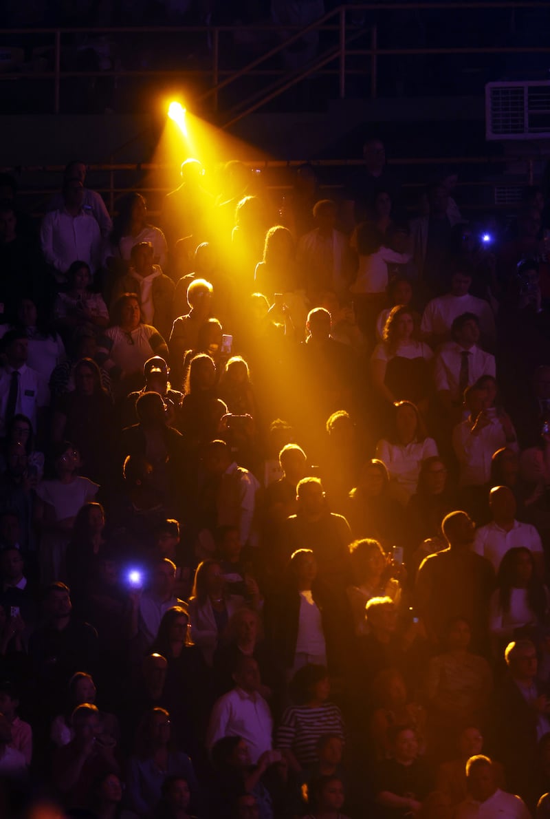Audience members stand and are illuminated by yellow spot lights during the “Hallelujah” from Handel’s "Messiah"  during the "Songs of Hope" tour concert by The Tabernacle Choir and Orchestra at Temple Square at Ginasio do Ibirapuera in São Paulo, Brazil, Friday, Feb. 27, 2026.