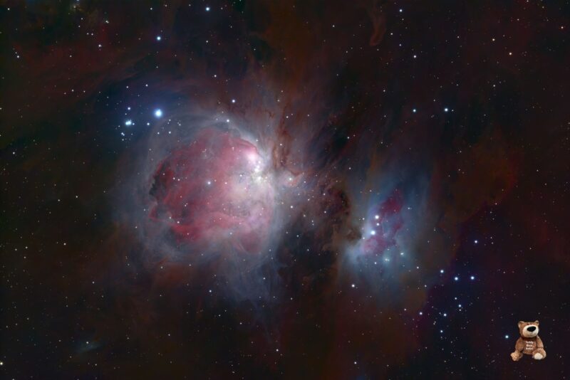 Large swirls of bright, electric pink and blue nebulosity over a background of prolific stars.