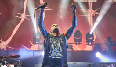 Phil Anselmo, lead vocalist of Pantera, performing live on stage with intense energy and iconic microphone stance