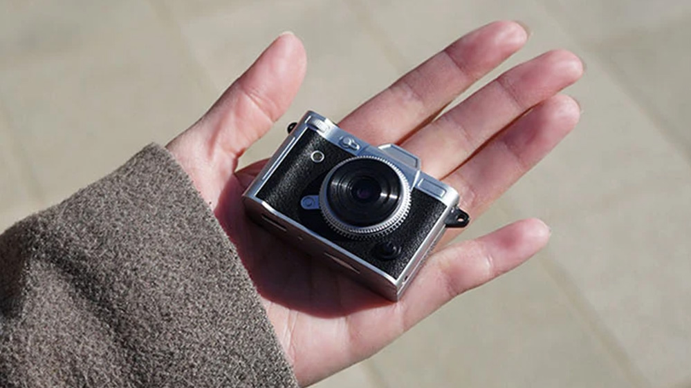 A small camera in the palm of a hand.