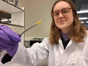 Researcher holding a piece of compleximer with tweezers