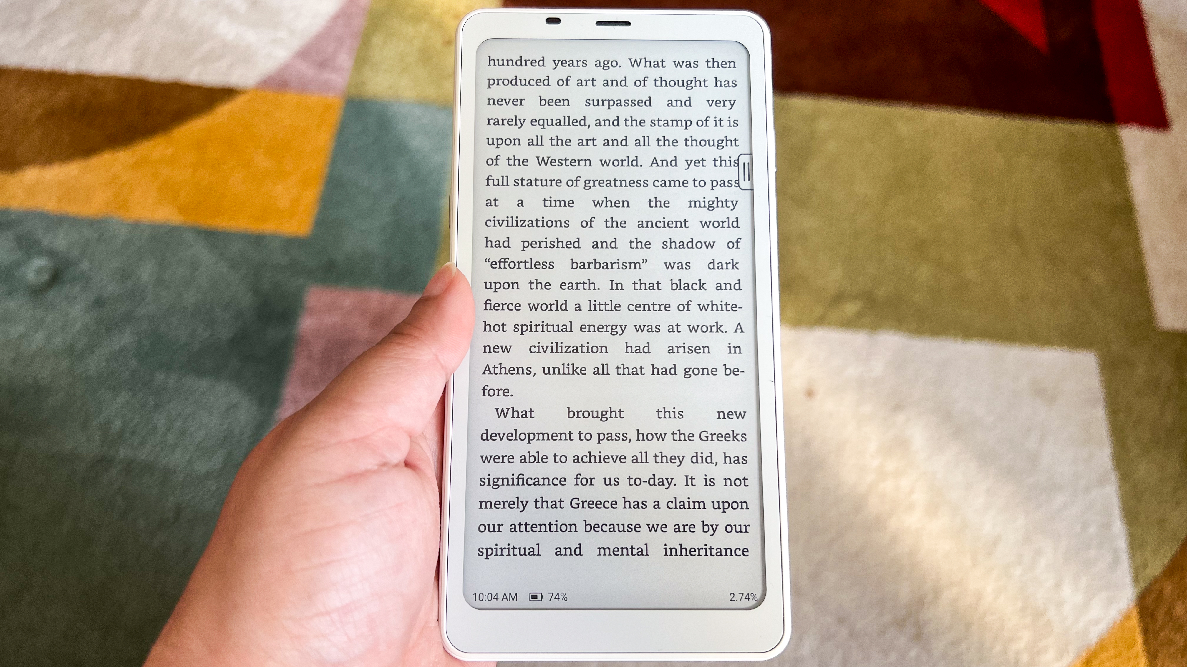 A hand holding the Onyx Boox Palma 2 with a page of an ebook displayed