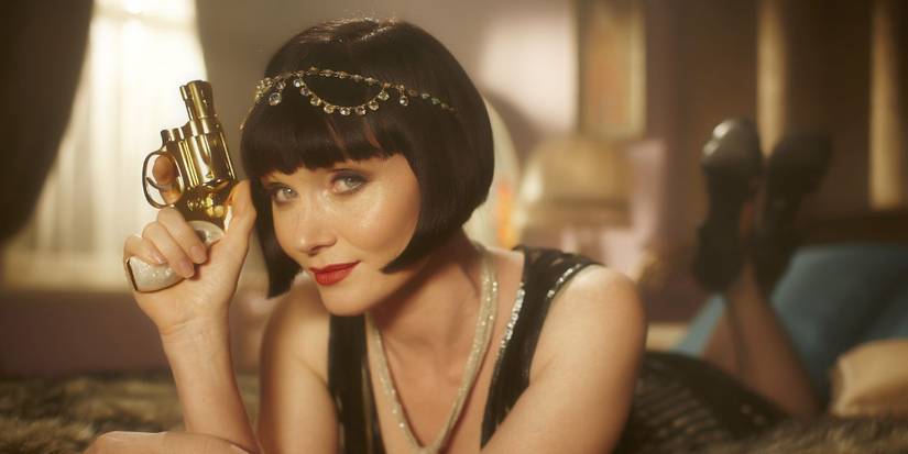 Phryne Fisher (Essie Davis) holding a gun on Miss Fisher's Murder Mysteries