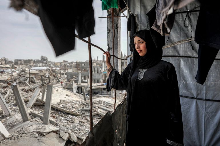 Etedal Rayyan (29), who recently returned back to Gaza from Egypt through the Rafah border crossing, looks out the window of her heavily-damaged house in the Jabalia camp for Palestinian refugees in the northern Gaza Strip on February 8, 2026.
