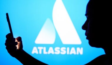 an Atlassian logo on a blue background with a person silhouetted in front holding a phone, for some reason