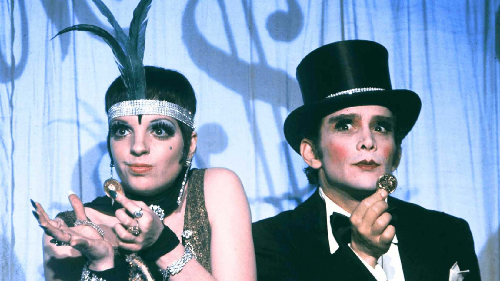 Sally and the Emcee hold coins while performing onstage in Cabaret