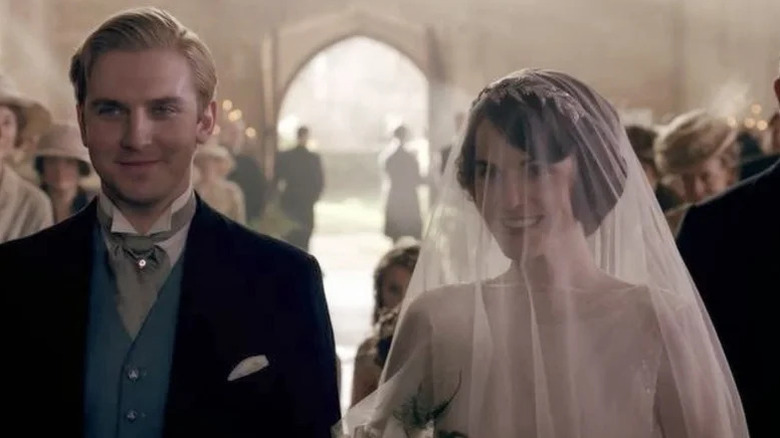Matthew Crawley (Dan Stevens) stands next to Mary Crawley (Michelle Dockery) as they are married in a church in Downton Abbey