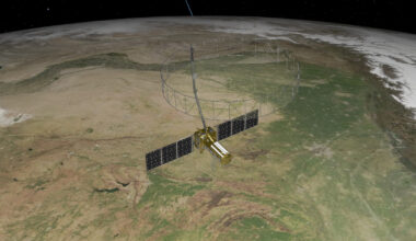 A 3D rendering of a satellite with solar panels and a wire mesh antenna orbiting Earth. The Earth is textured with continents and oceans. The satellite is in the foreground against a dark background with stars.