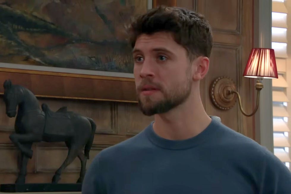 emmerdale, joe tate in a blue top in front of the fireplace