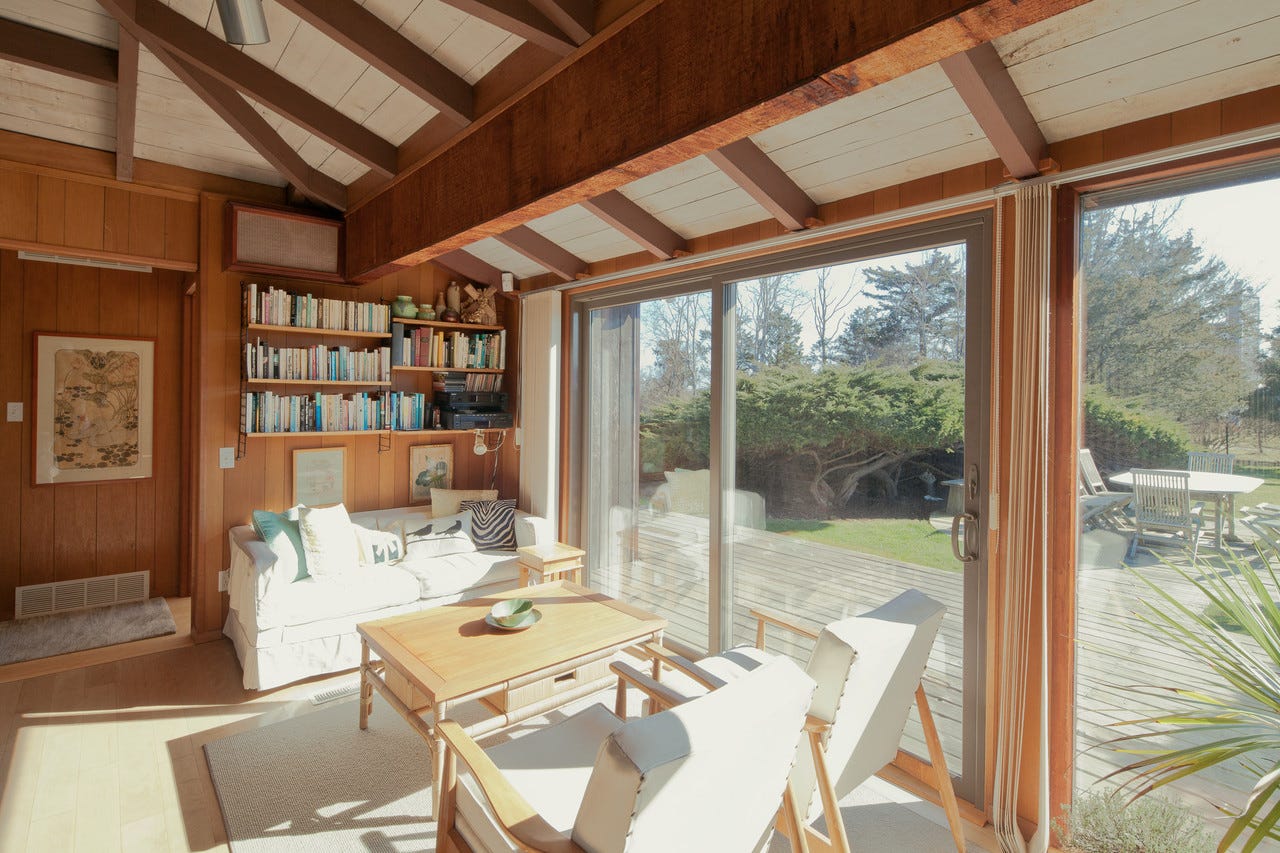 Cozy living room with wooden accents and large windows.