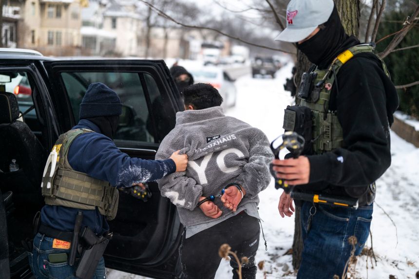 A man is detained by a Border Patrol agent on January 21 in Minneapolis.