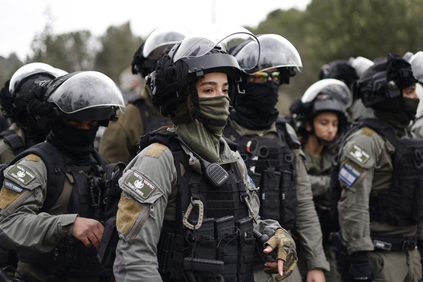 Members of the security forces stand guard as Palestinian citizens of Israel gather in Sakhnin to protest on January 22.