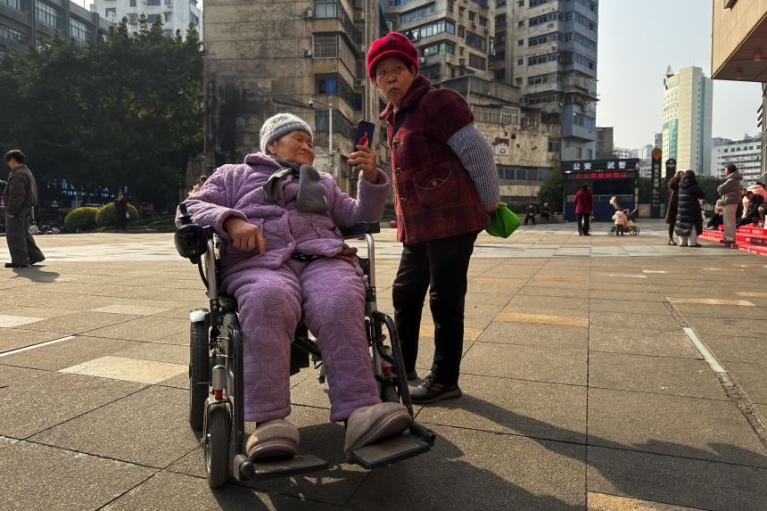 Two elderly women meet in a square in Chongqing in January.