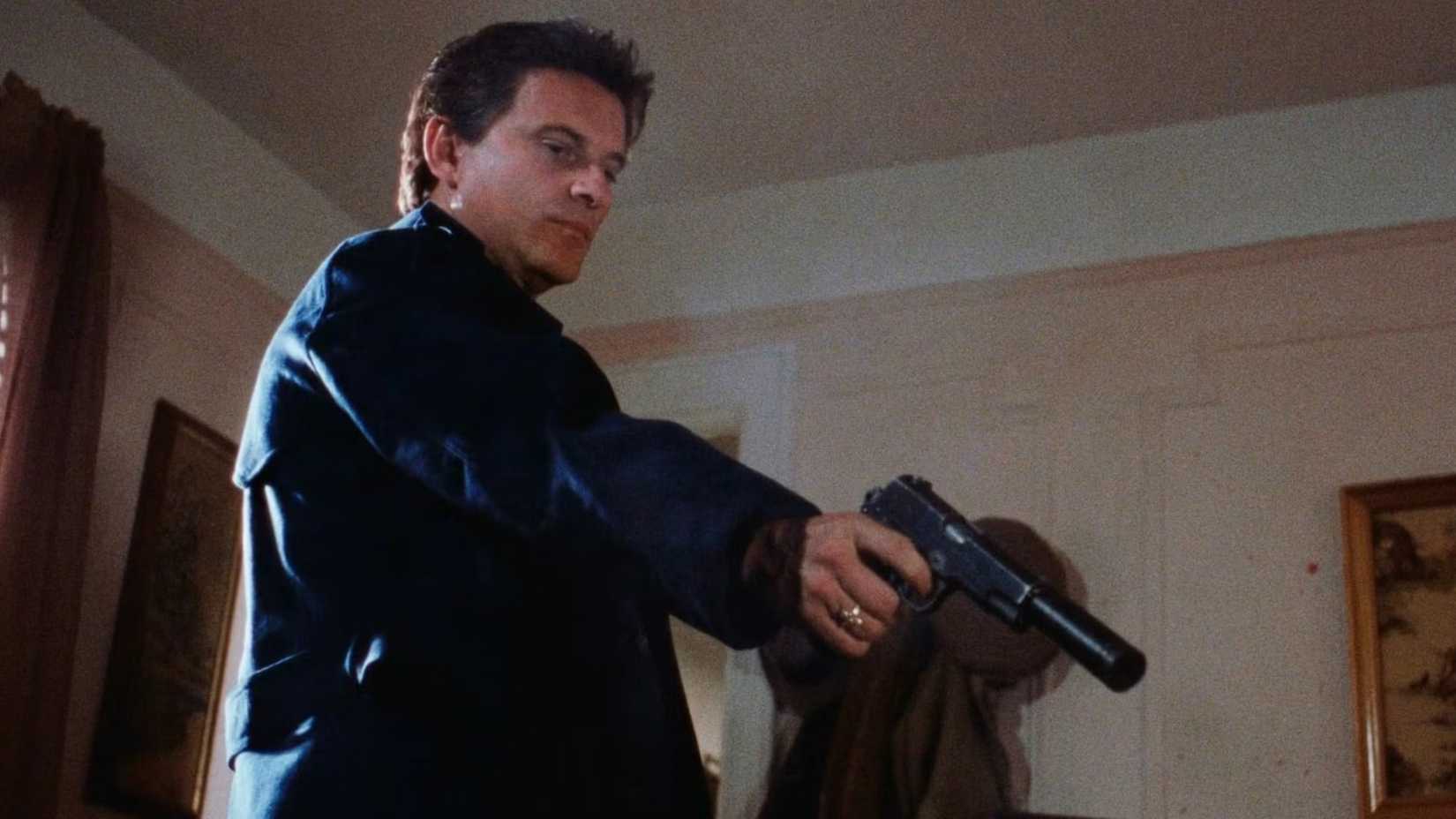 Joe Pesci points a pistol at someone offscreen in Goodfellas