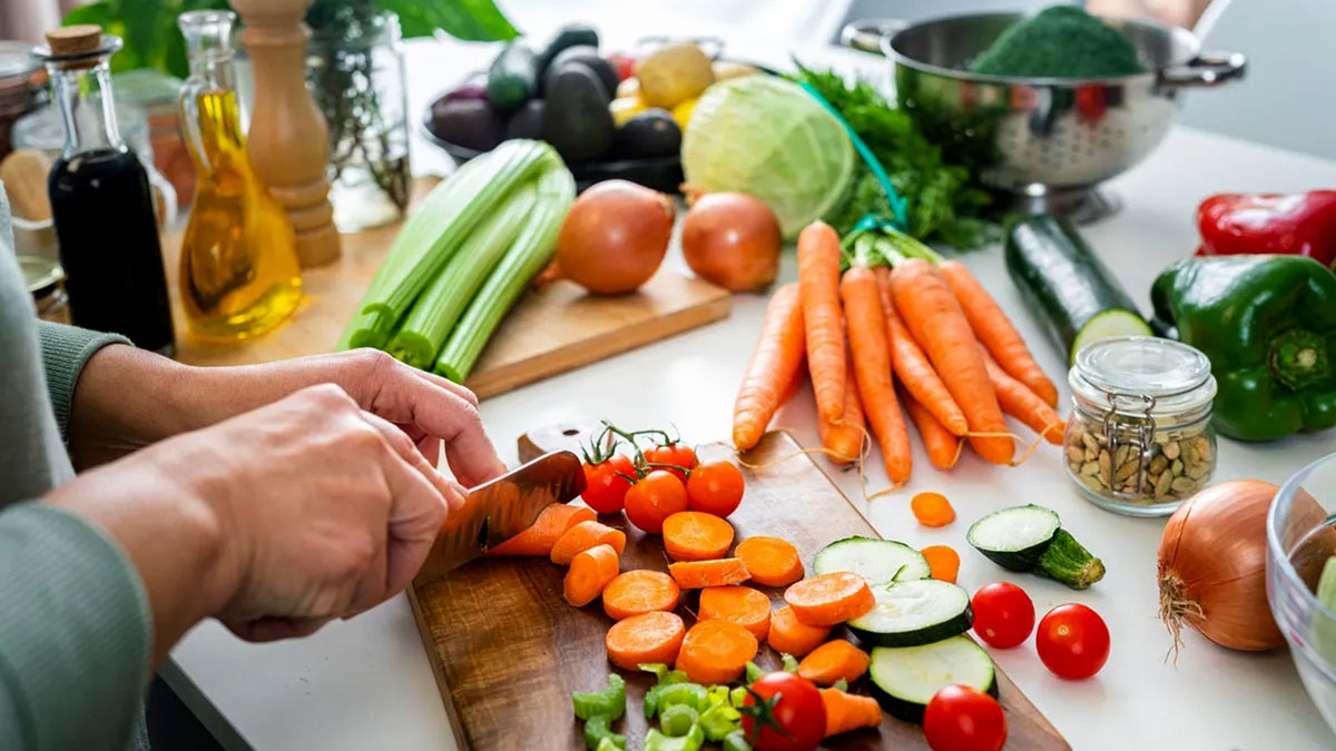 Healthy Whole Foods, mainly vegetables, being chopped on counter