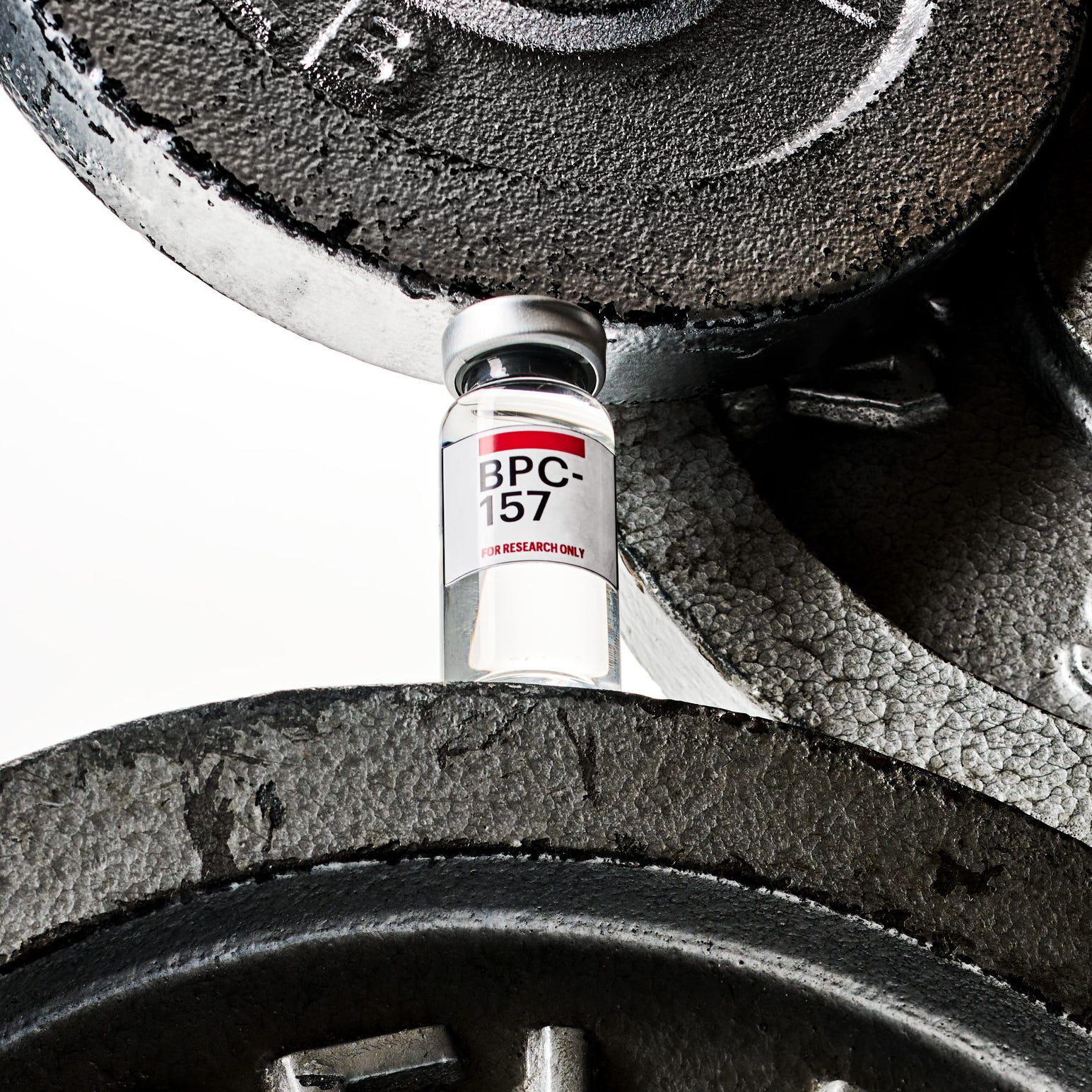 vial of bpc157 positioned among weightlifting plates vial of bpc157 positioned among weightlifting plates