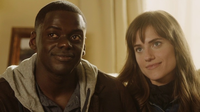 Daniel Kaluuya and Allison Williams as Chris and Rose sitting together in Get Out