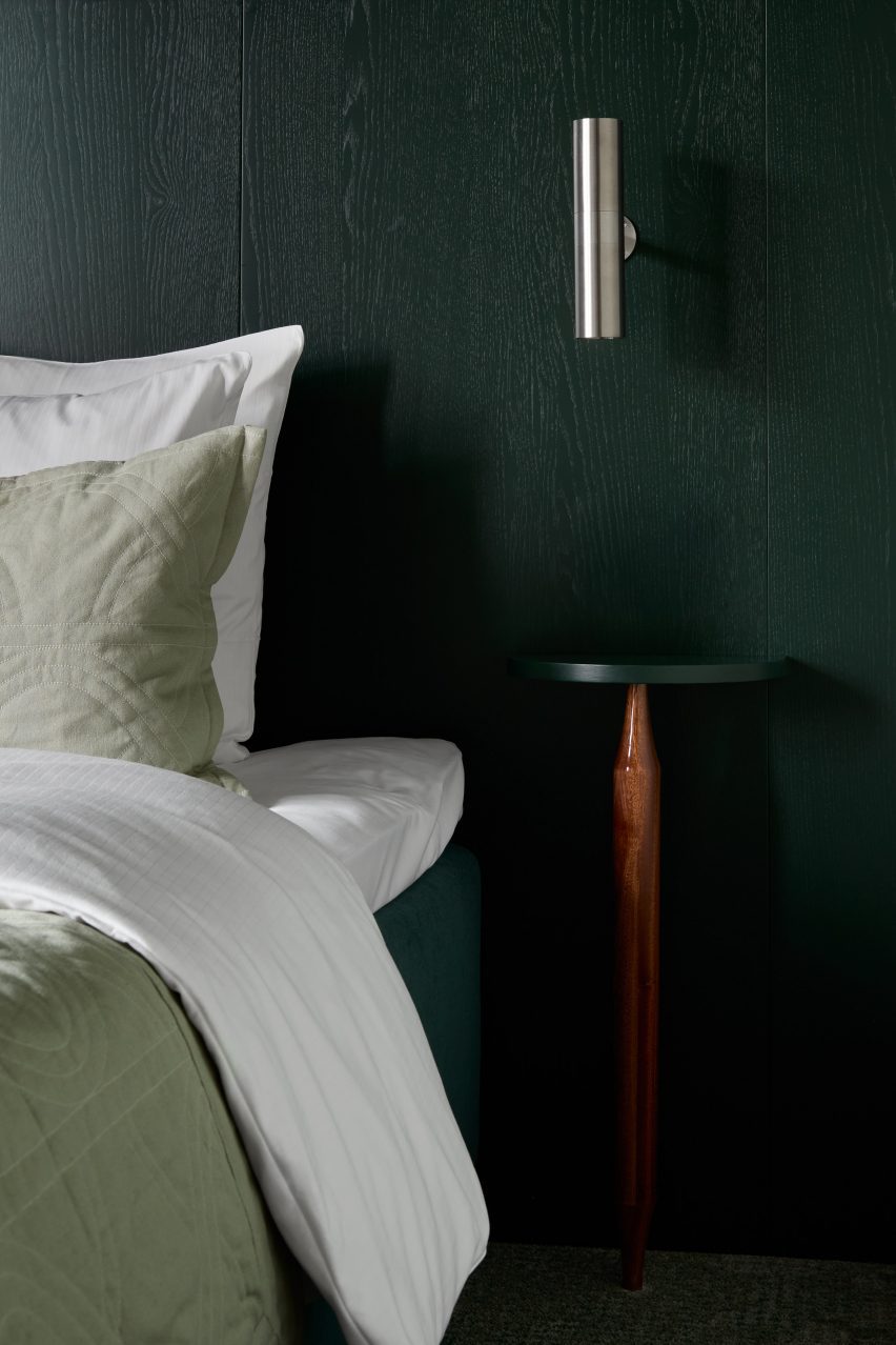 Bedroom with green walls and metal lamp