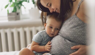 Young woman with her first child during second pregnancy. Motherhood and parenting concept. Toddler boy and mom. Happy family expecting for baby.