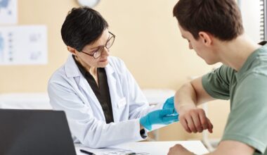 Portrait of mature female doctor inspecting patient with skin rash during consultation in dermatology clinic