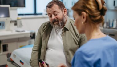 Doctor checking blood glucose level using a fingerstick glucose meter, waiting for results from glucometer. Obese or overweight man at risk of developing type 2 diabetes. Concept of health risks of overwight and obesity.