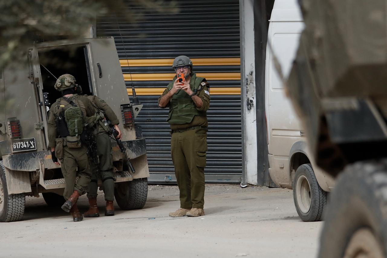 An Israeli soldier films journalists during a raid in al-Yamun town west of Jenin in the occupied West Bank on February 17, 2026. (AFP Photo)