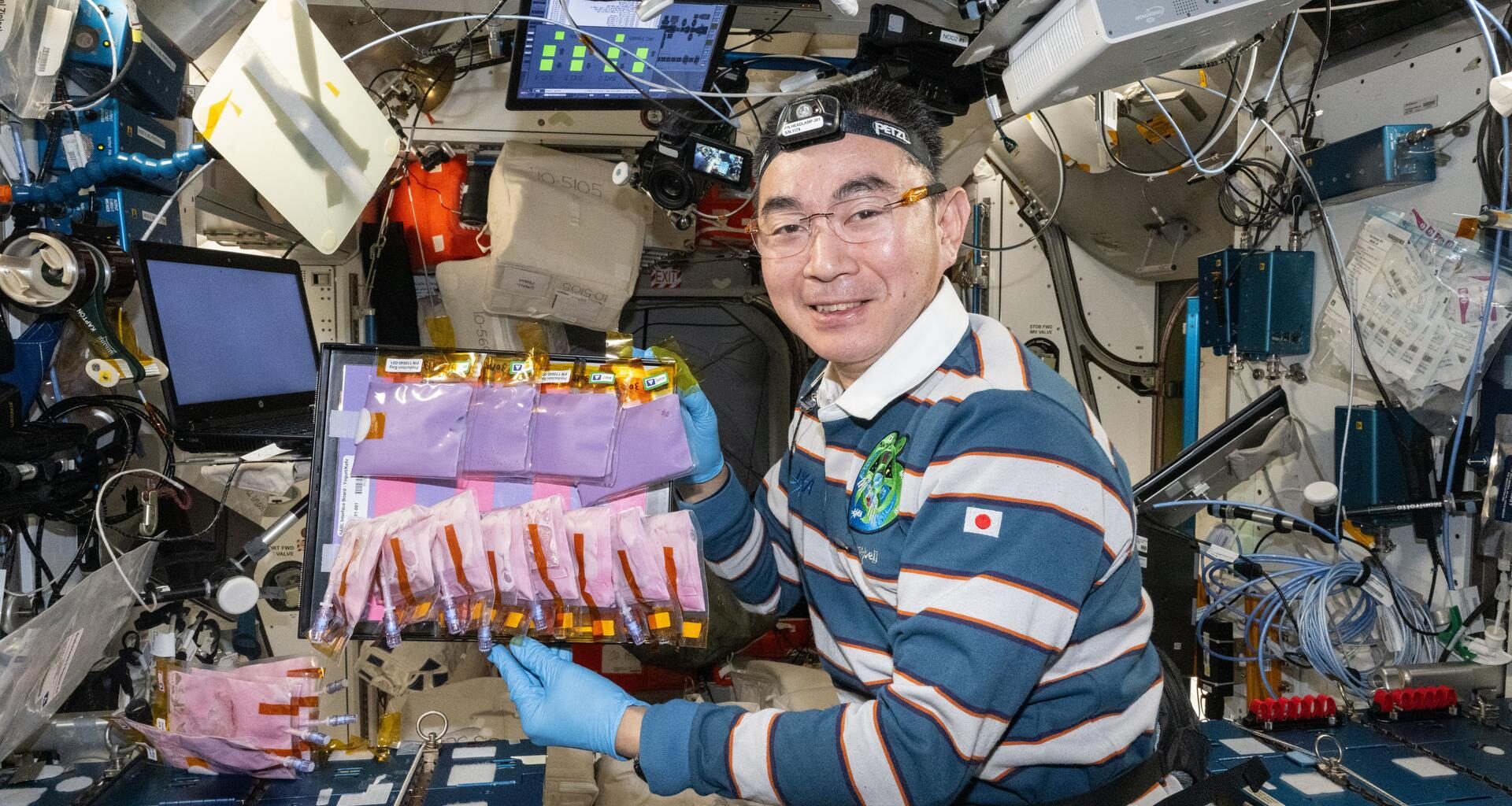 JAXA (Japan Aerospace Exploration Agency) astronaut and Expedition 73 Flight Engineer Kimiya Yui shows off production bags containing bioengineered yeasts and probiotic cultures for the BioNutrients-3 investigation. Yui conducted passaging and straw tests to demonstrate how astronauts could grow and safely consume fresh vitamins and nutrients on demand helping researchers plan future missions farther from Earth.