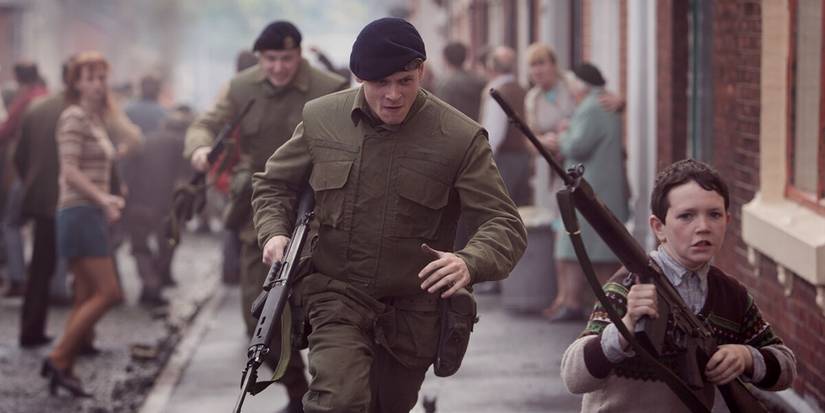 Jack O'Connell as Gary in soldier's uniform running after a child with a gun in '71 (2014)