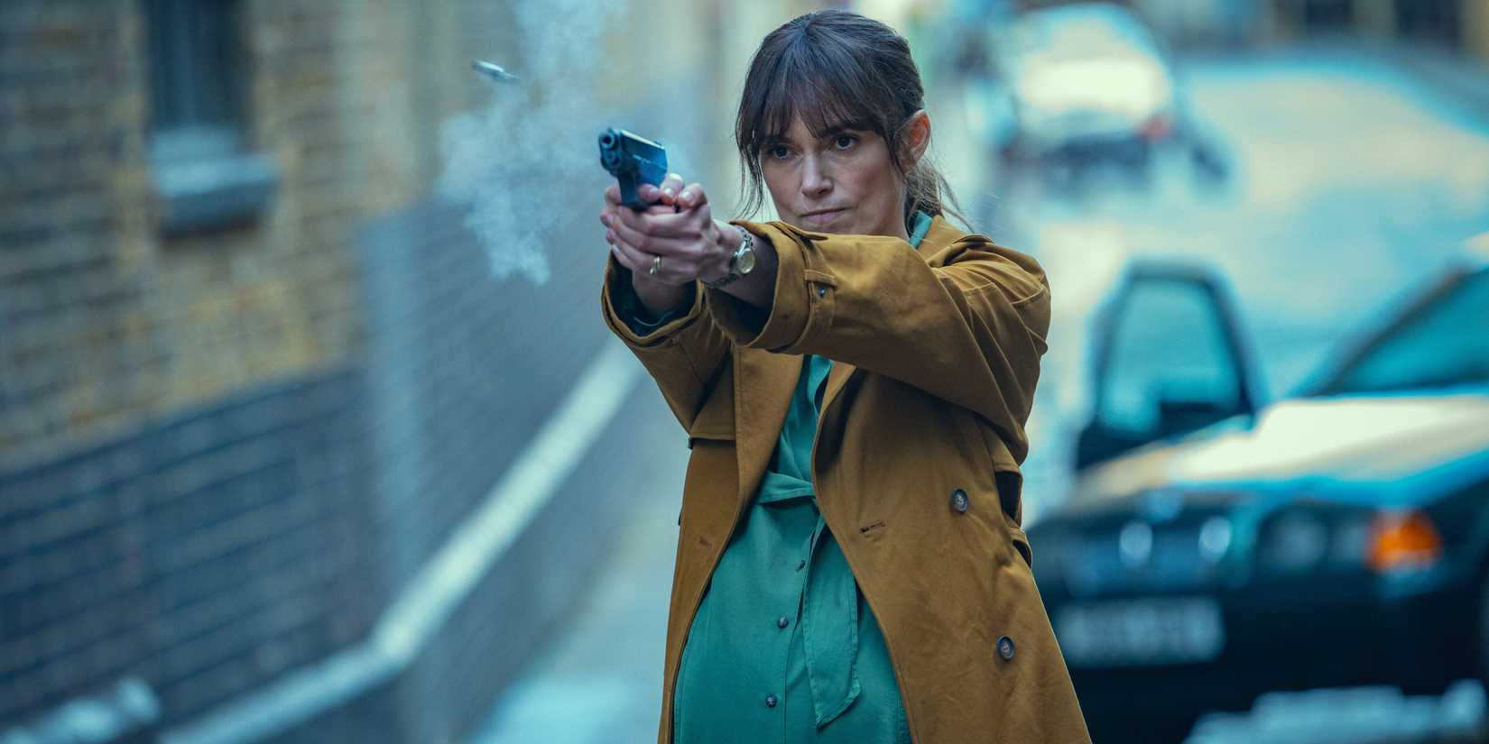 Keira Knightley as Helen firing a pistol in front of a car in Black Doves season 1
