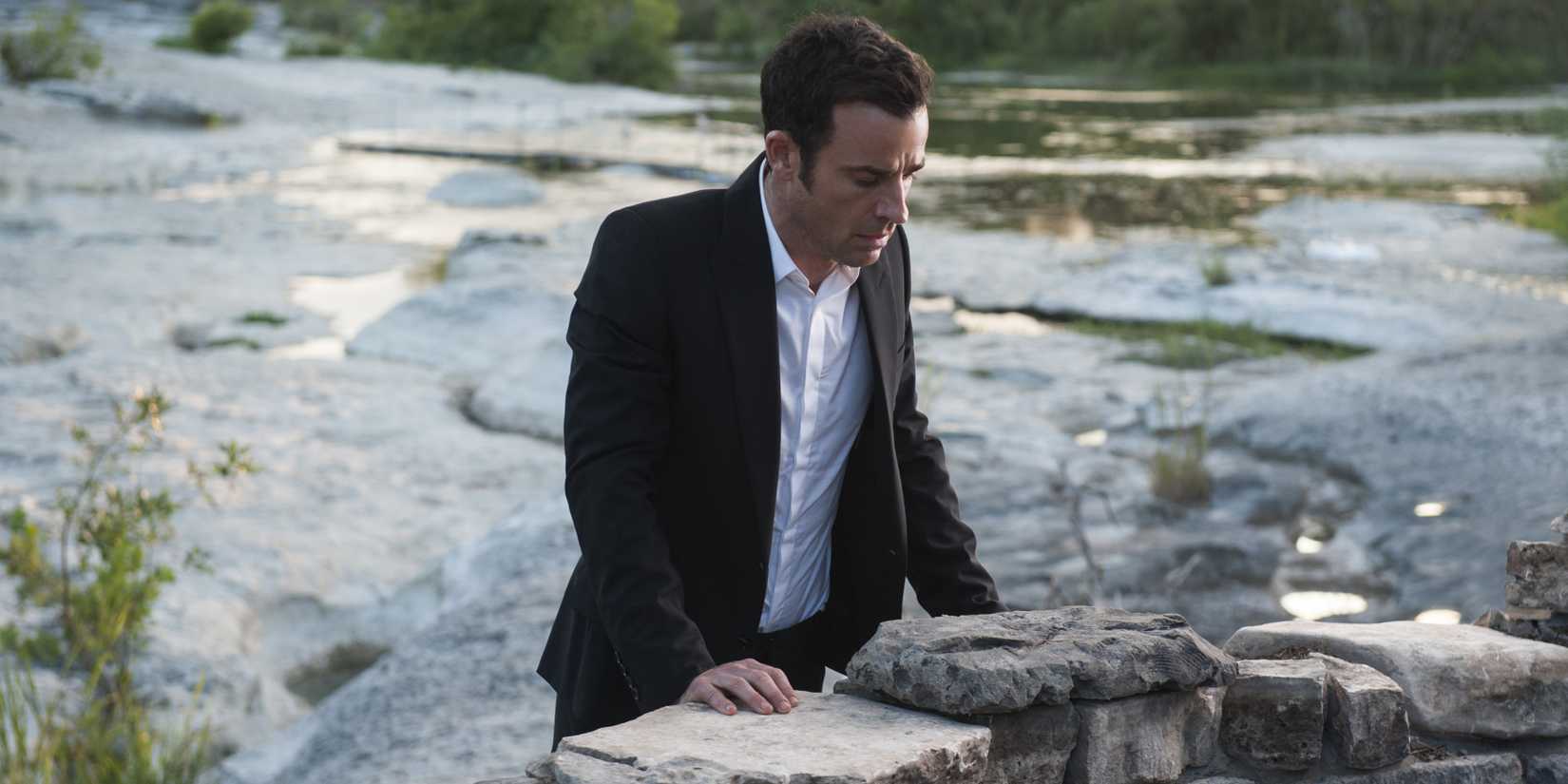 Kevin standing against a stone wall in The Leftovers