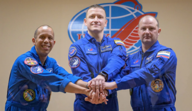 Three astronauts wearing blue flight suits