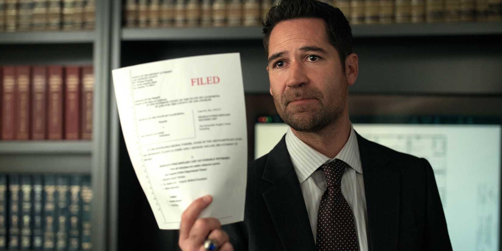 Mickey holds up a document in The Lincoln Lawyer