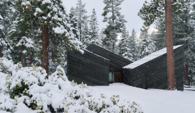 cedar-clad 'staggered cabin' by mork-ulnes steps down a forested slope above lake tahoe
