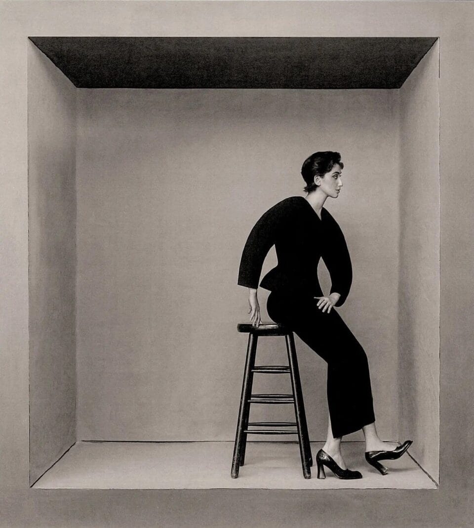 an editorial portrait by Szilveszter Makó of a woman in a cube posing against a stool