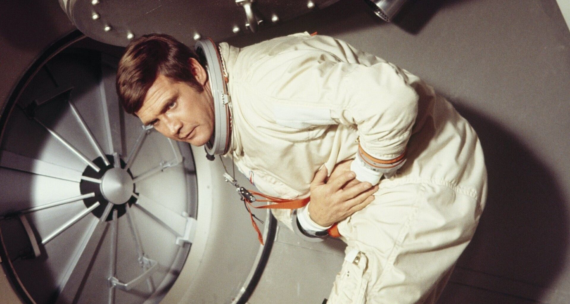 A man in space holding his stomach.