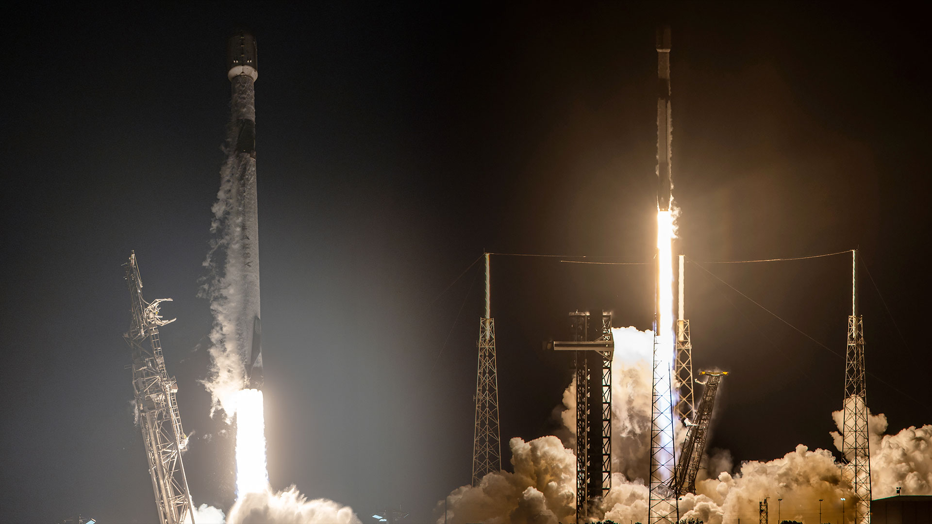 Side-by-side photos of white and black rockets lifting off into the dark of night and their engine plumes lighting the surrounding area of their launch pads