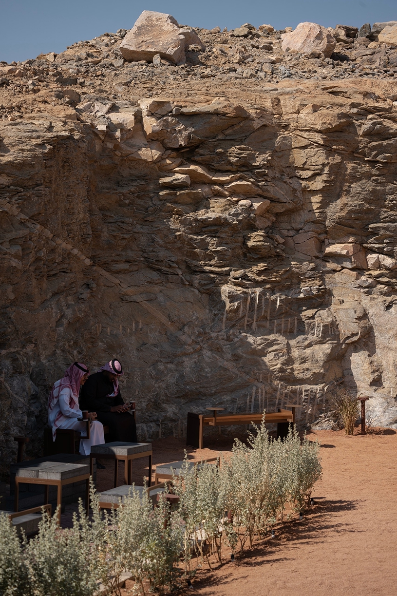 open planted courtyard organizes a café carved directly into rock in saudi arabia