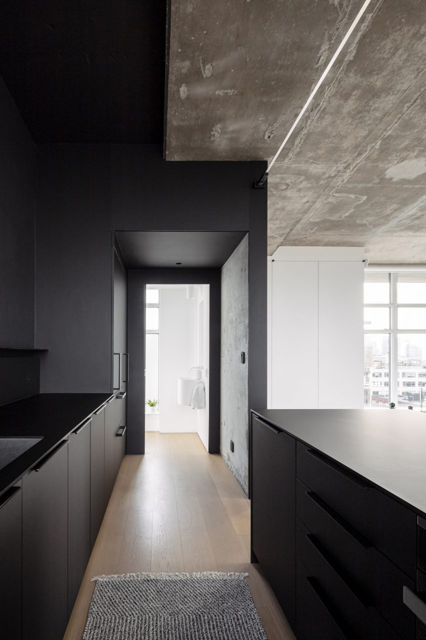 An entirely matte black kitchen tucked into a niche
