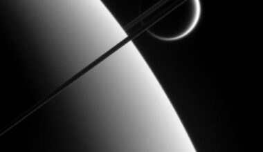The Cassini spacecraft captured this image of Titan framed by Saturn and its rings. New research highlights Titan's important role in shaping the Saturnian system. Image Credit: NASA/JPL/Space Science Institute