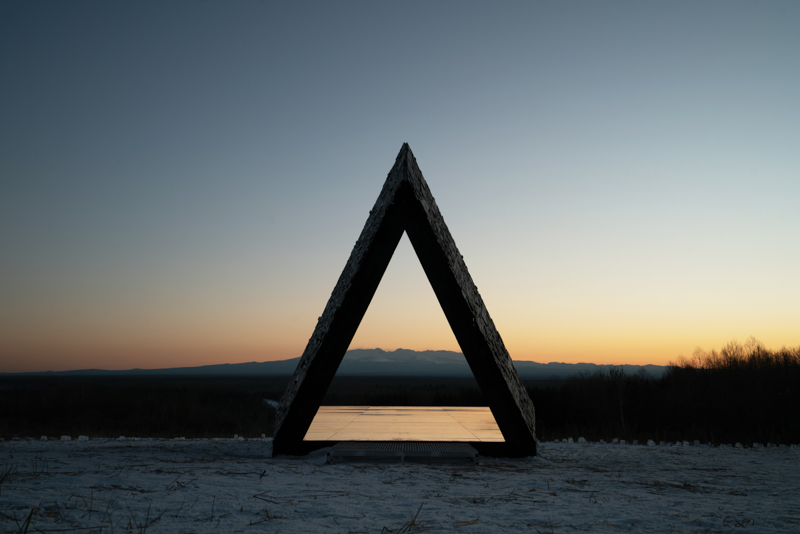 reflective red chamber emerges from prism mountain shelter’s charred wood shell