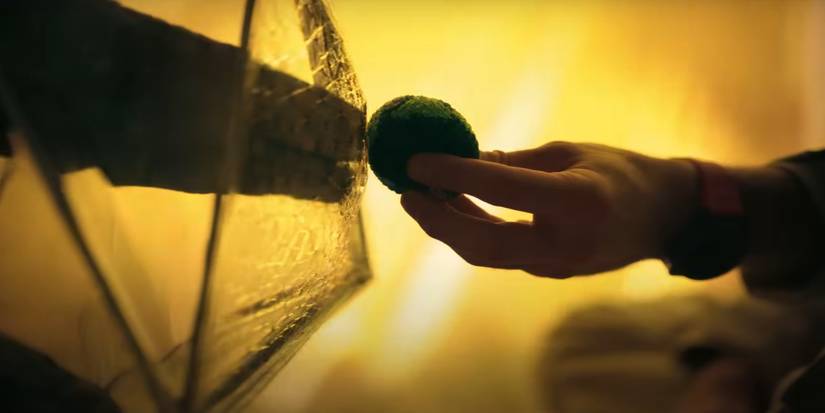 A rocky hand reaches out to grap an object held by a human hand in Project Hail Mary